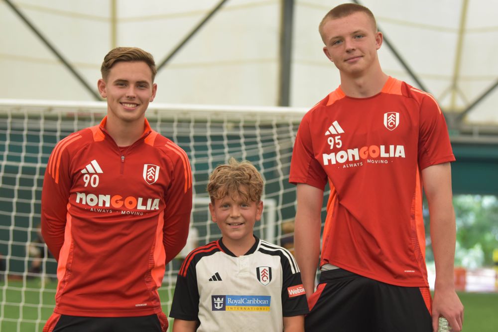 Fulham Under-18s players Harley Platel and Logan Cooke pose for a photo with a Soccer Schools participant 
