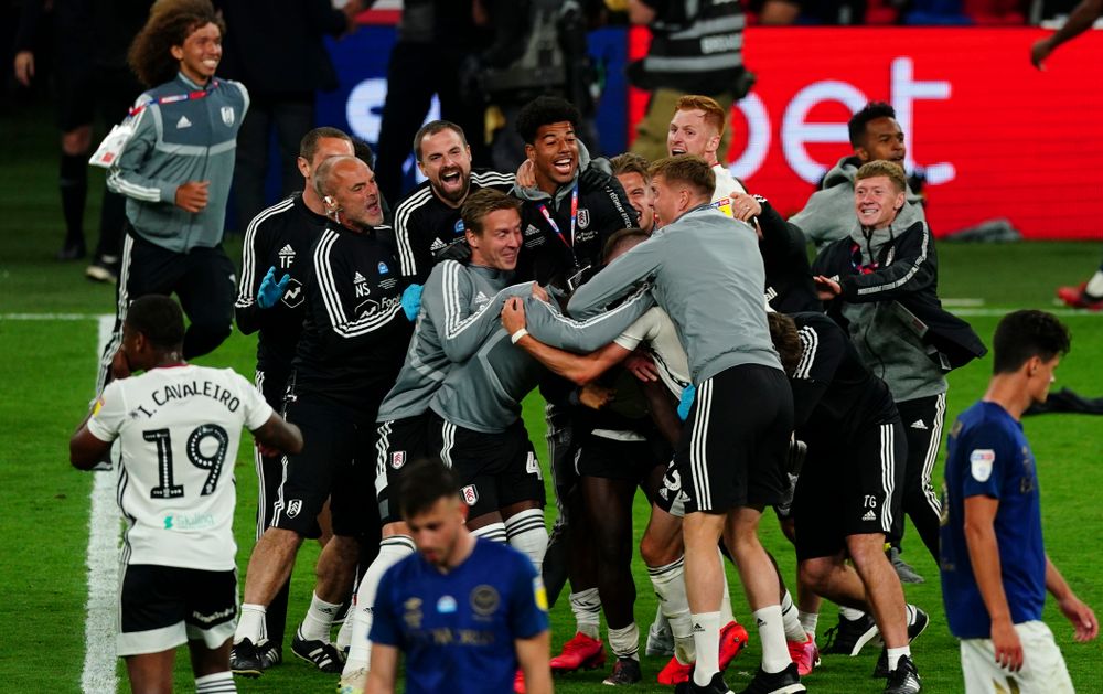Fulham staff, including Mark Harrison, celebrate at full-time