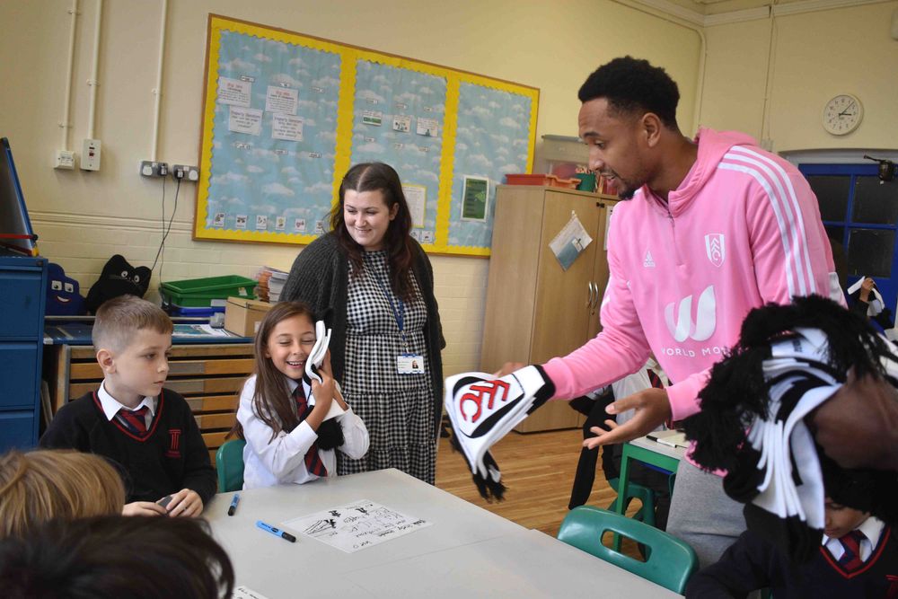 Kenny hands out Fulham scarves to the students
