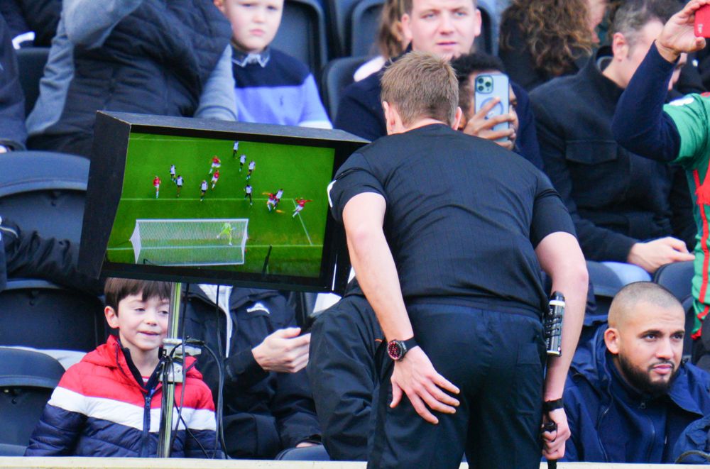 The referee inspects the VAR screen
