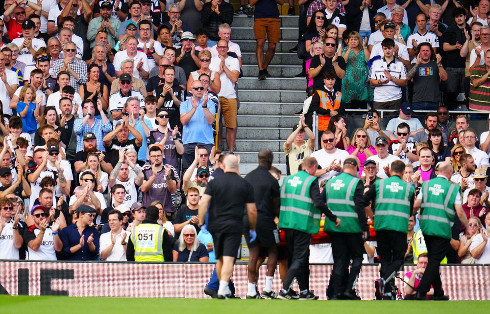 Fulham fans applaud Chris Basham as he's stretchered off
