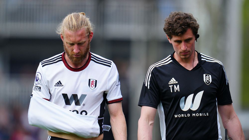 Tim Ream is escorted off the pitch with his arm in a sling made out of his shirt