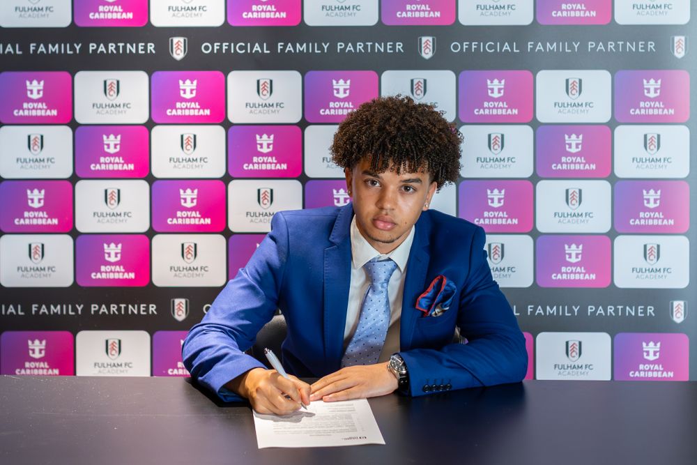 Aidan Evans signs his scholarship agreement