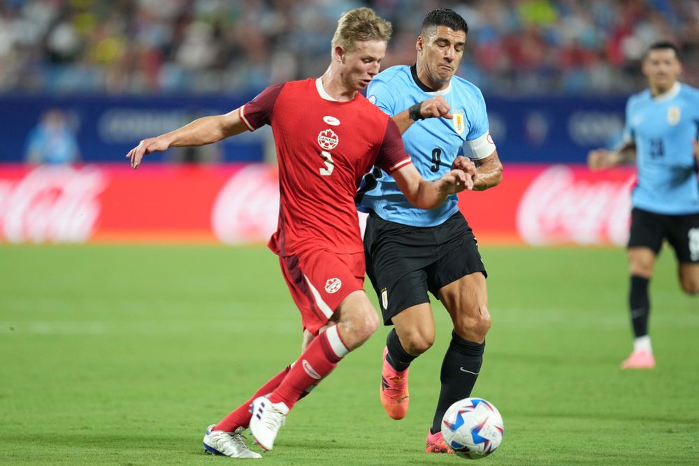 Luc de Fougerolles battles for the ball with Uruguay striker Luis Suárez Luc de Fougerolles battles for the ball with Uruguay striker Luis Suárez