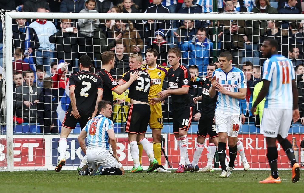 Marcus Bettinelli's teammates congratulate him after he saves a penalty at Huddersfield Marcus Bettinelli's teammates congratulate him after he saves a penalty at Huddersfield
